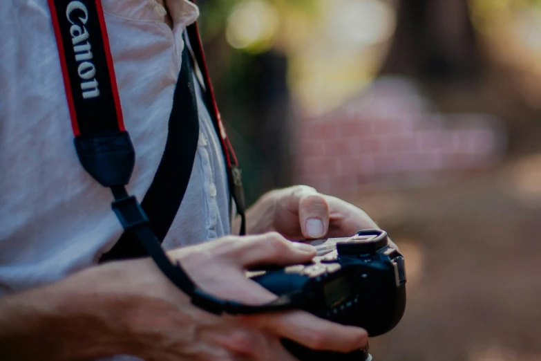 a man holding a camera while wearing a strap