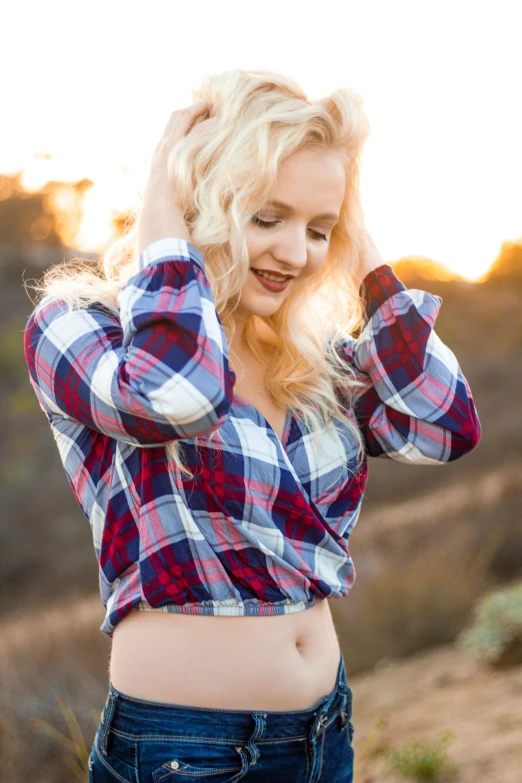 a woman wearing high waisted jeans and a on up plaid shirt