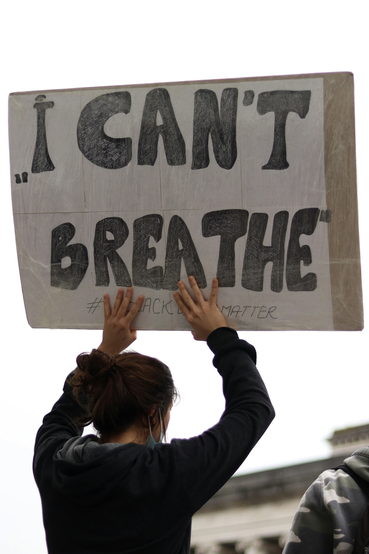 someone holding up a cardboard sign with writing