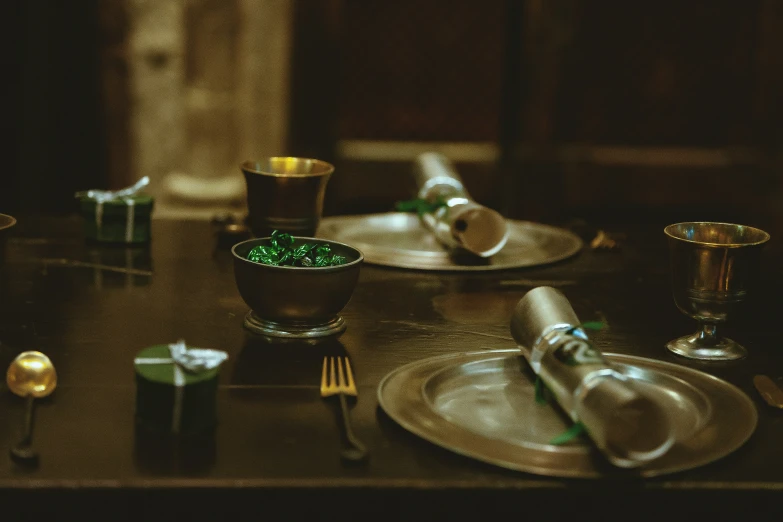 this table has green candles, glasses and two empty plates