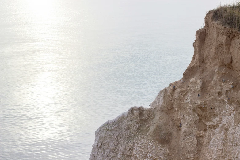 the cliff with a clock on it is next to the sea