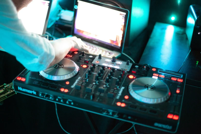 a dj plays the music on his dj equipment