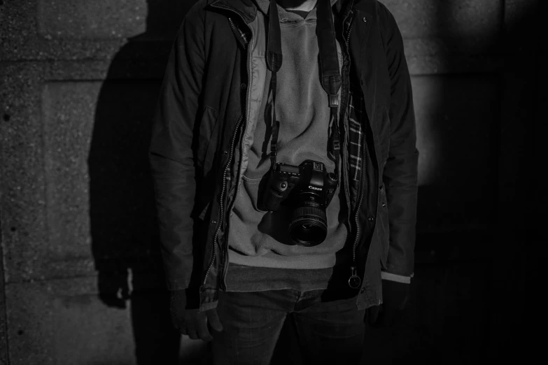 a man in a coat and hat holding a camera