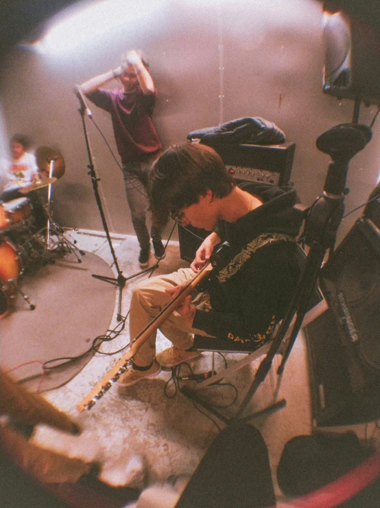 a man sits in a chair with microphones and music equipment