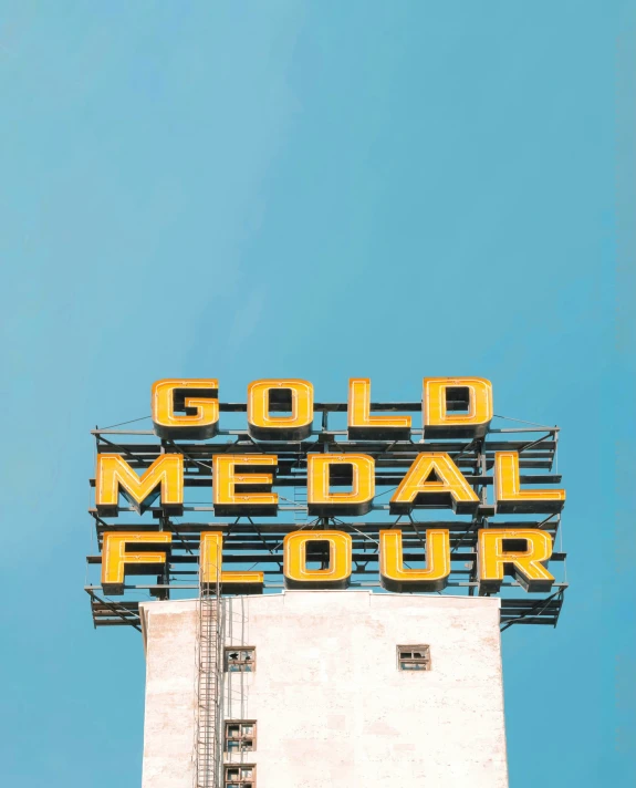 a yellow sign reading gold medal flour on top of a building