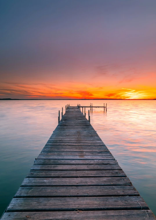 an ocean scene with a dock stretching out into the water