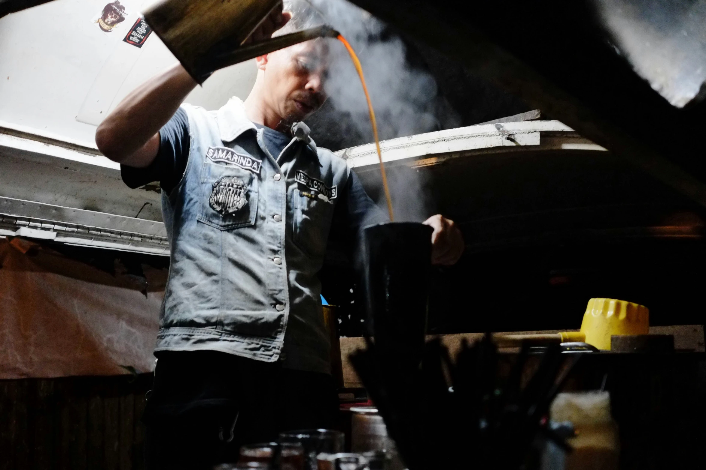 a man pours a bucket with liquid out of it