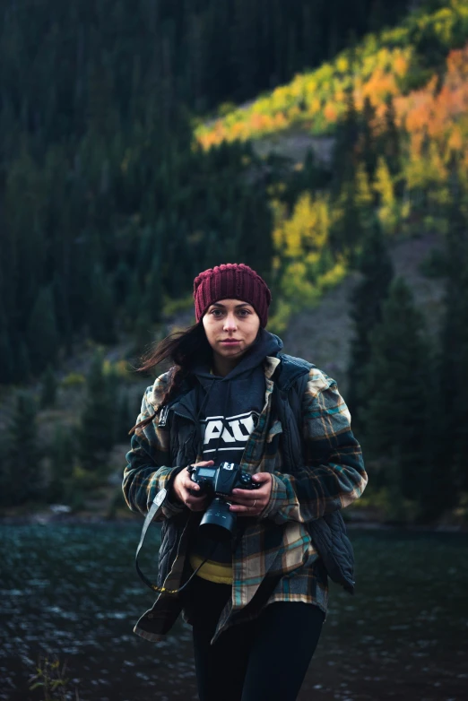 a woman in plaid jacket holding a camera