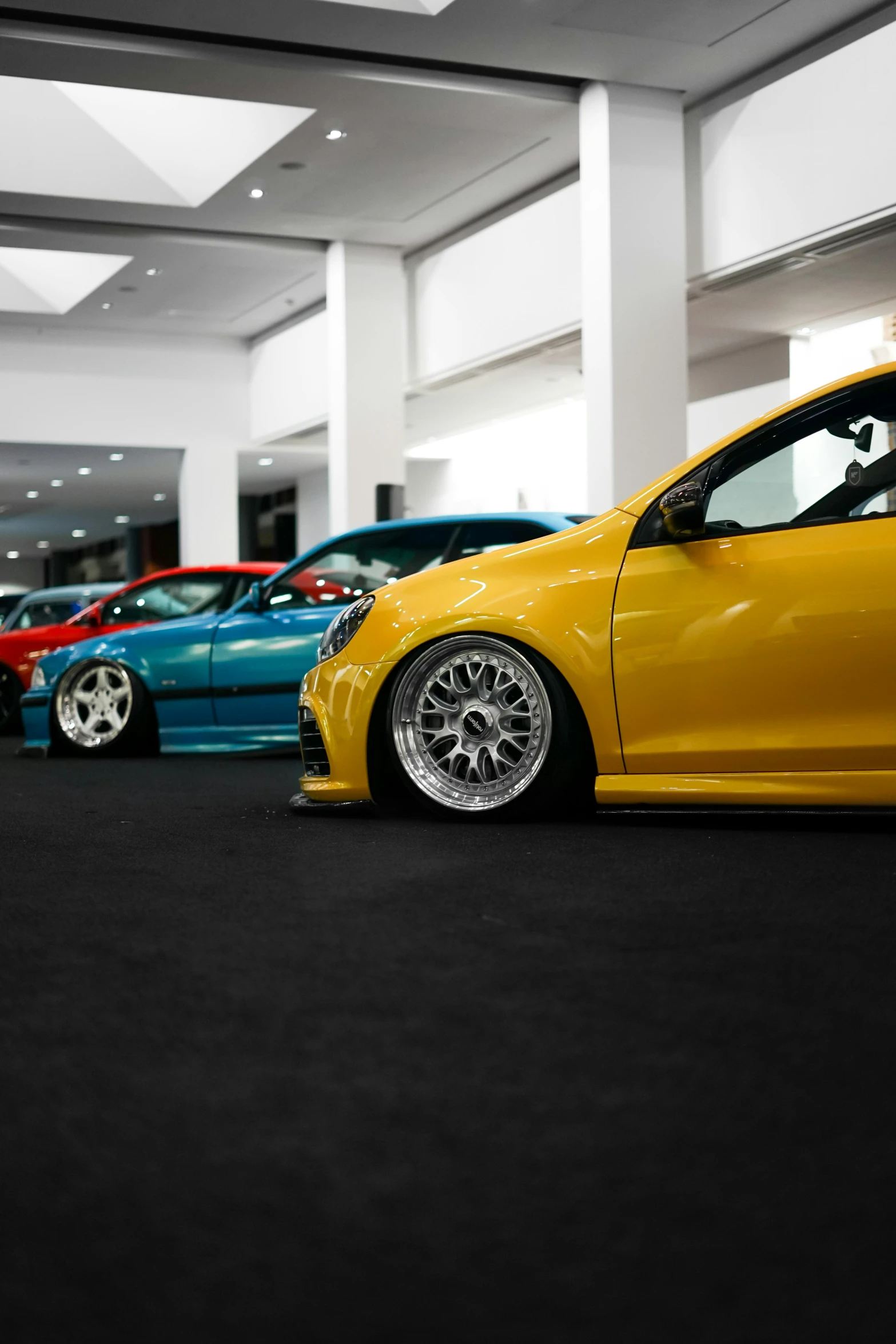 several different colors cars in a row on display