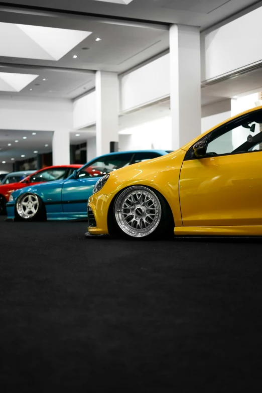 several different colors cars in a row on display