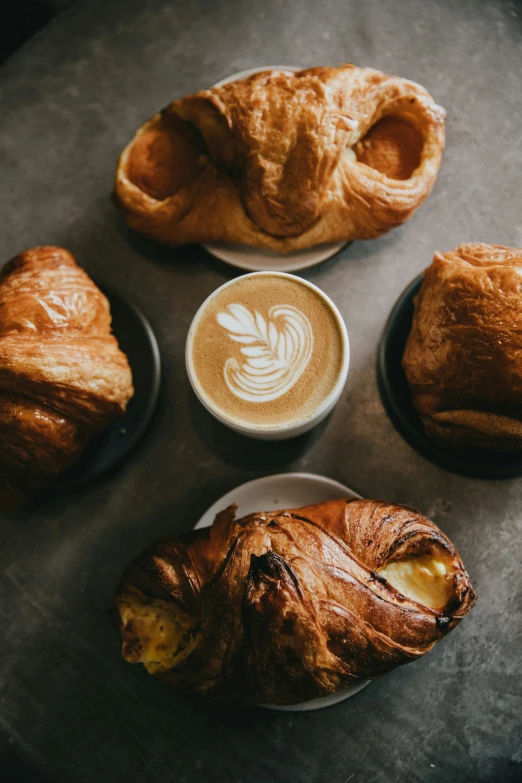 a table topped with a couple of breads and cups