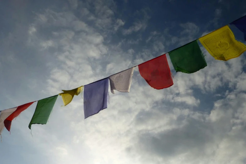 multi colored flags against a cloudy sky