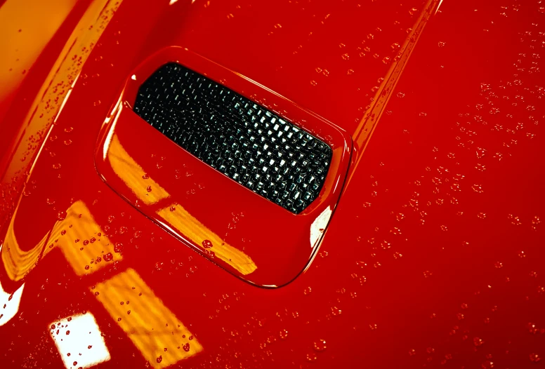 an orange truck with rain drops around the hood