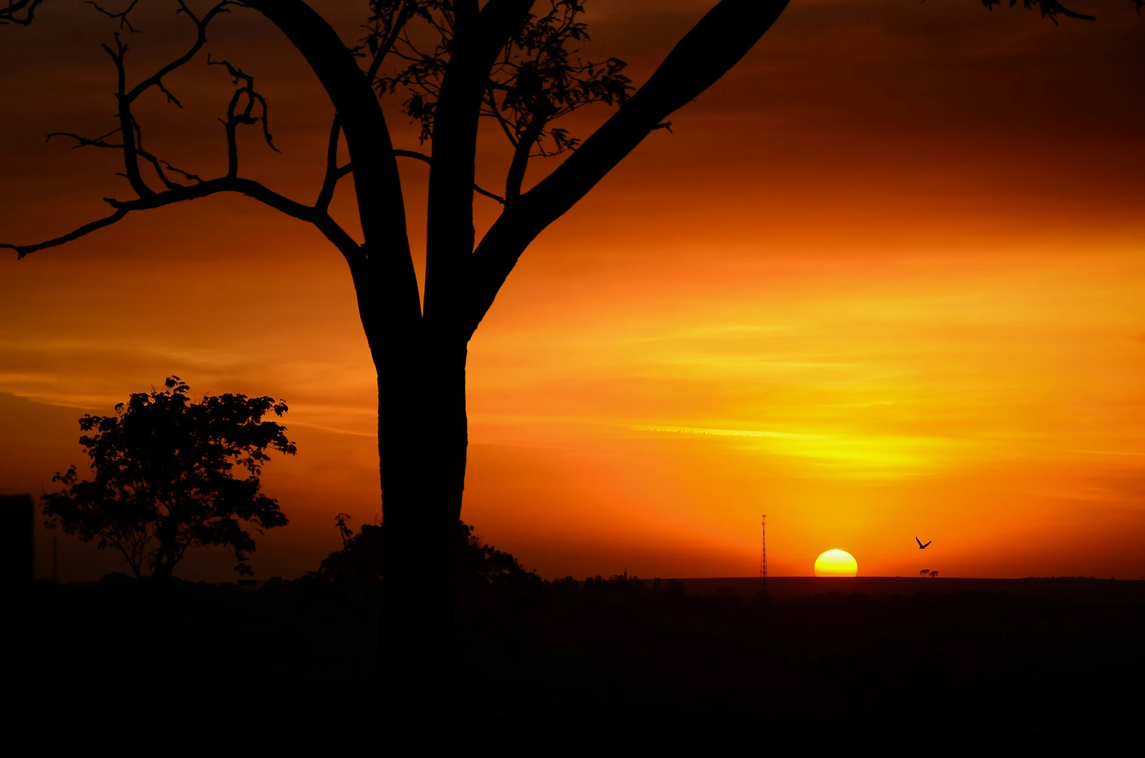 a large sun is setting on a cloudy day