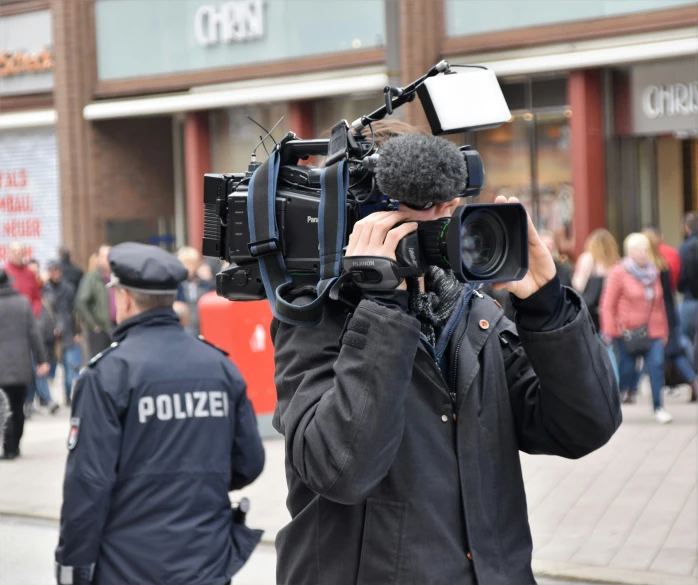 a person holding up camera equipment to record the street scene