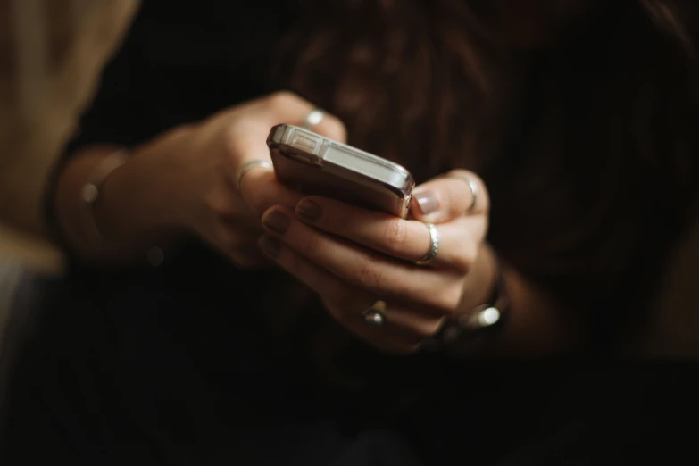 a woman is holding her cell phone in her hands