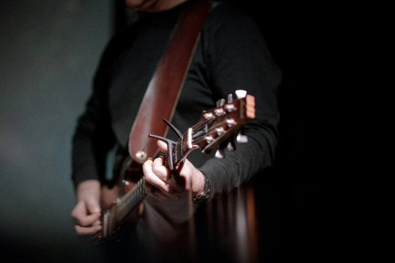 someone is playing an acoustic guitar in the dark