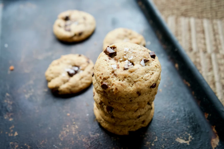 three chocolate chip cookies sitting on a cookie sheet