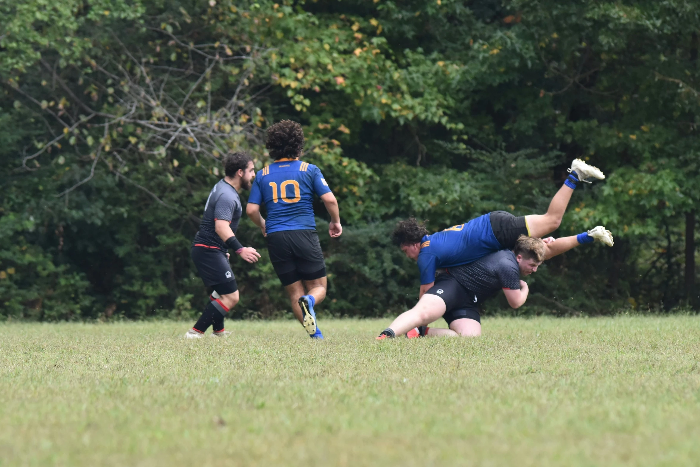 a team of players dives for the ball while another player looks on