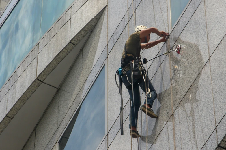 a person climbing up the side of a building with a harness