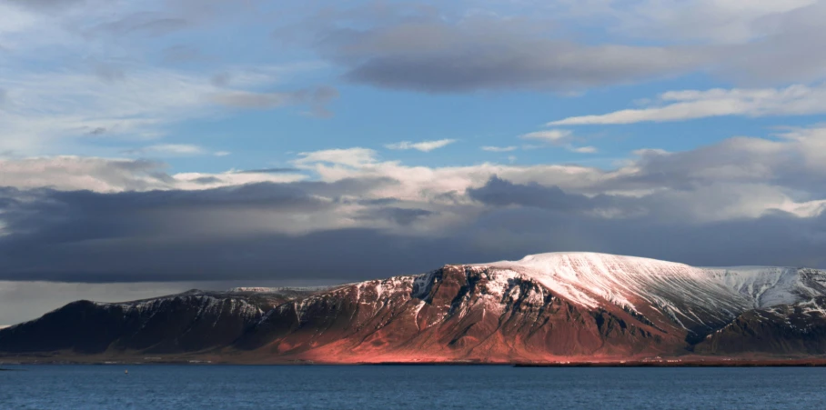 a snow covered mountain sitting on top of a lake