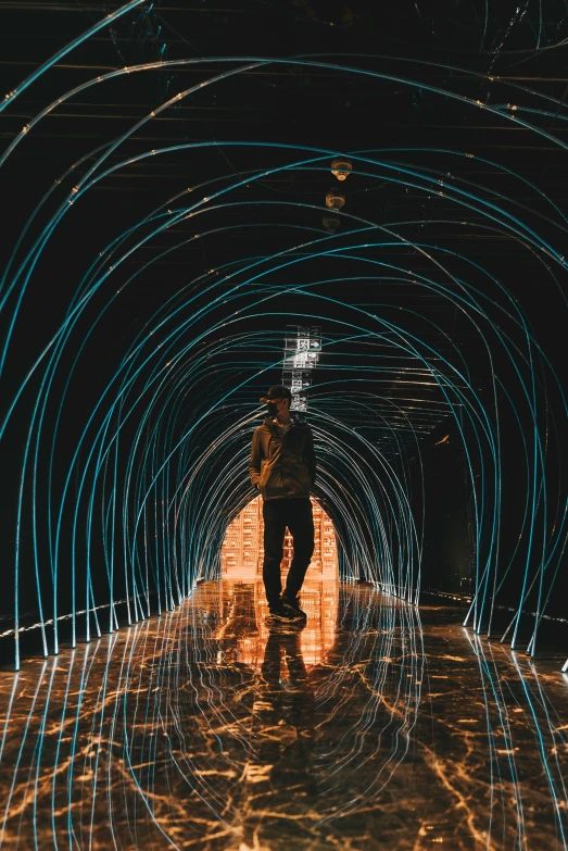 a person walking into a tunnel filled with blue lights
