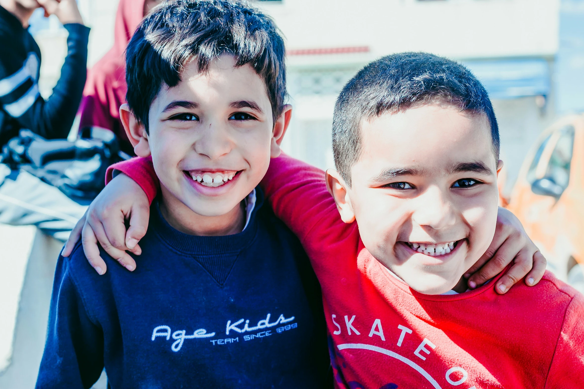 two small children are standing beside each other smiling