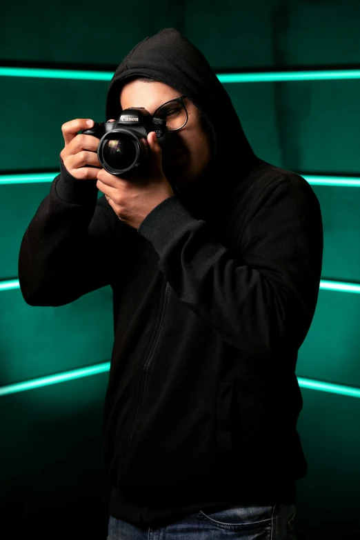a person in hooded clothing taking a pograph with his camera