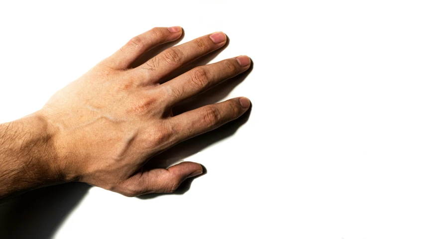 the left side of a person's hand holding soing in the air