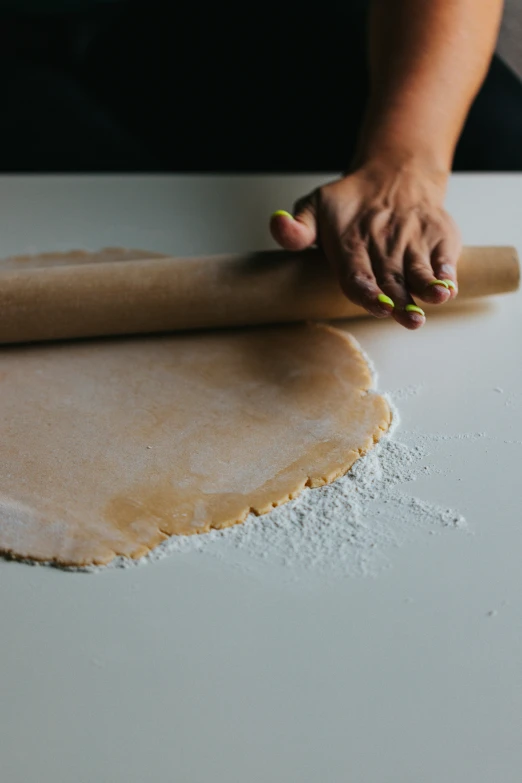 the rolling dough for pizza in a kitchen