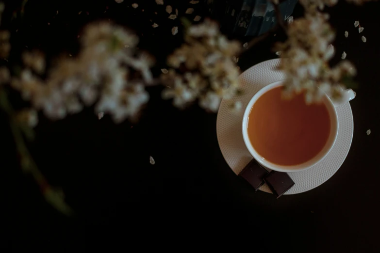 a cup of tea with chocolate and flowers