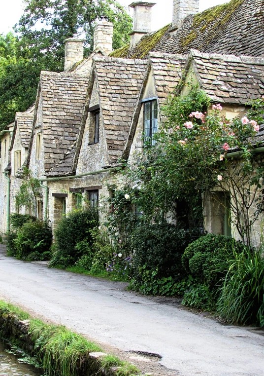 stone houses line a cobbled path through an english village