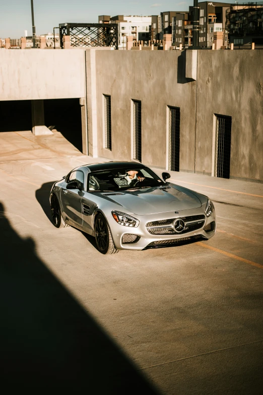 a silver sports car driving past an open parking garage door