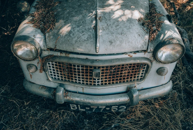 an old car is sitting in the grass