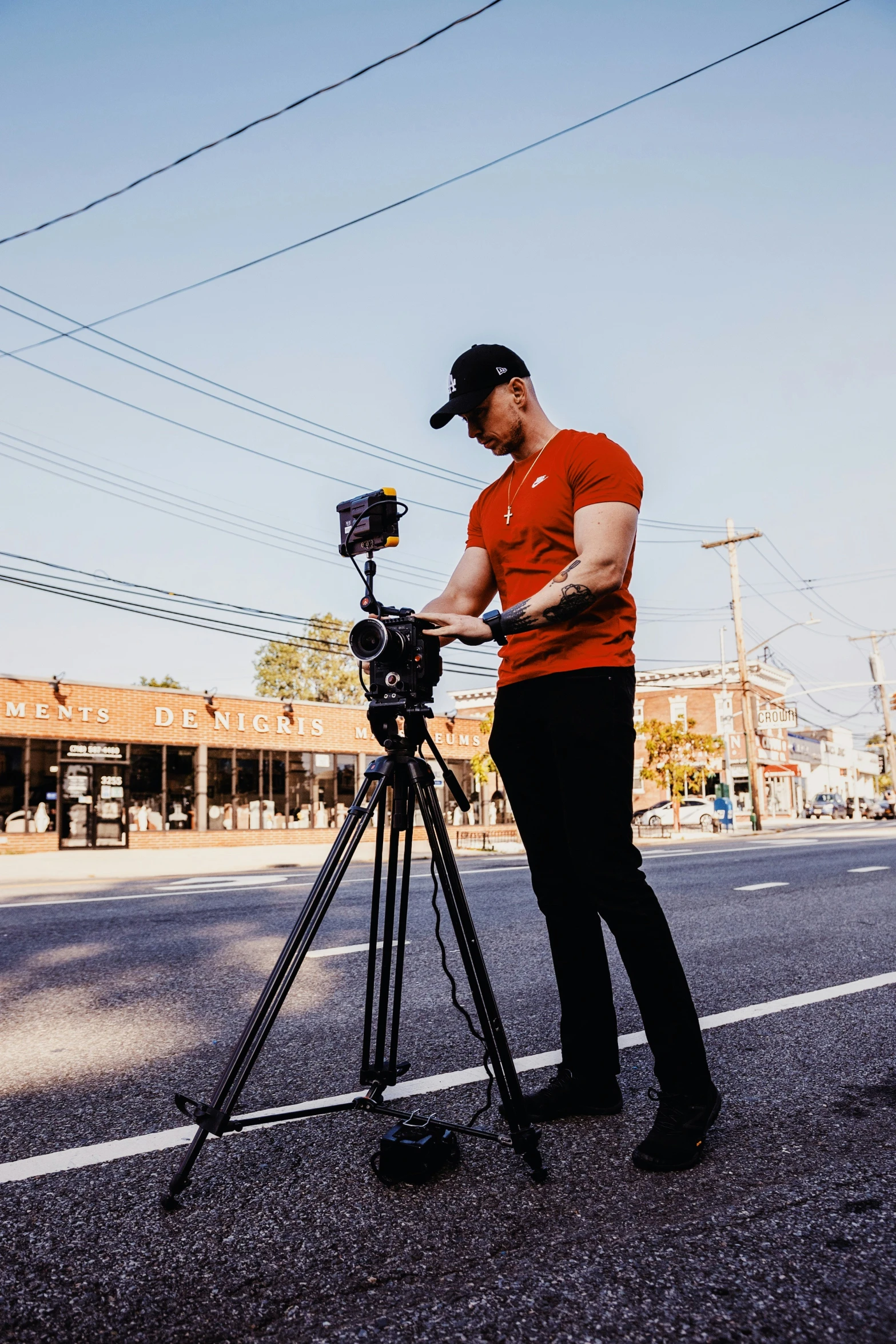 a man holding a camera next to a tripod