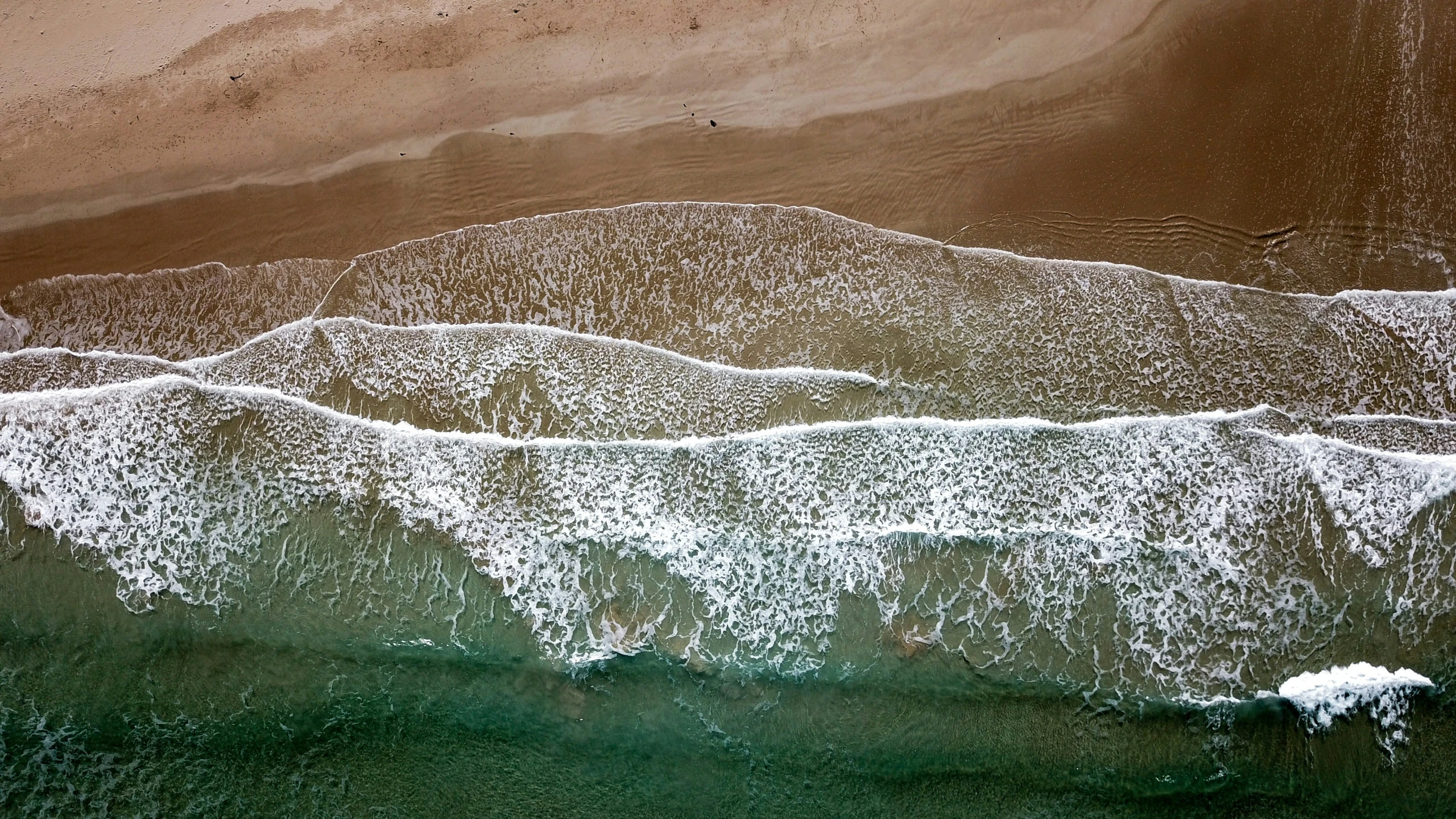 the beach is surrounded by an ocean and sand