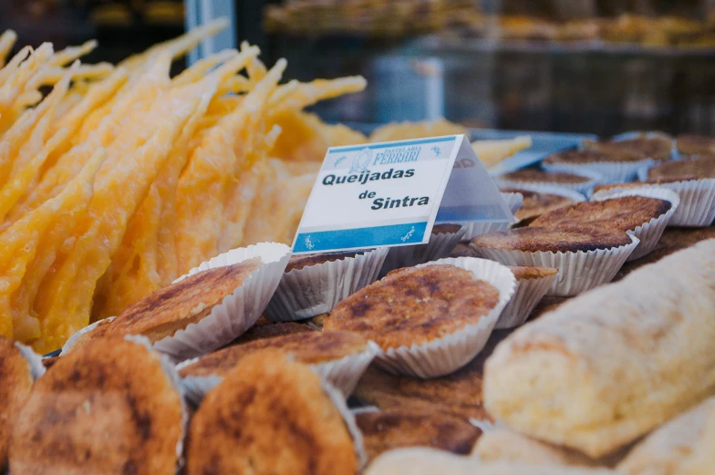 a closeup of breads, pastries and dips for sale at an outdoor food market