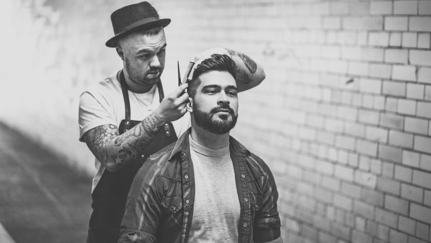 a black and white po of a man getting his hair cut