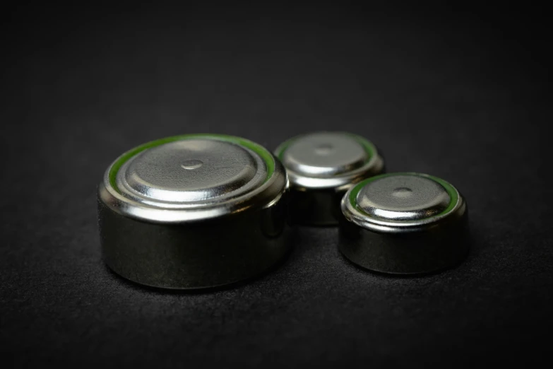 three small metal objects with one larger metal container on it