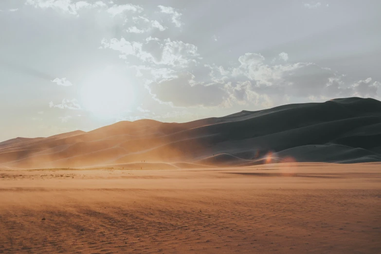 a dirt field with a large hill in the background