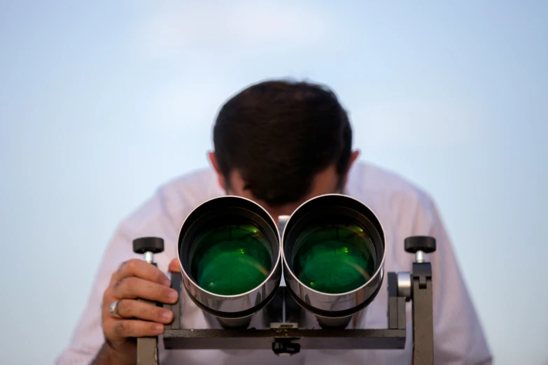 the man is looking through a pair of binoculars