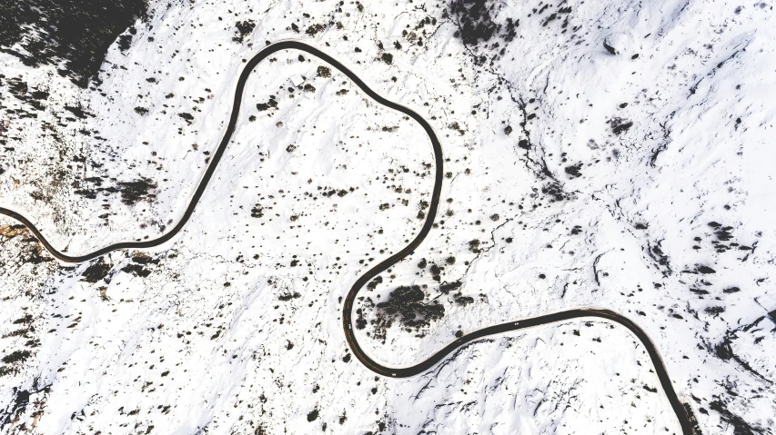 a car is driving in the snow along a trail