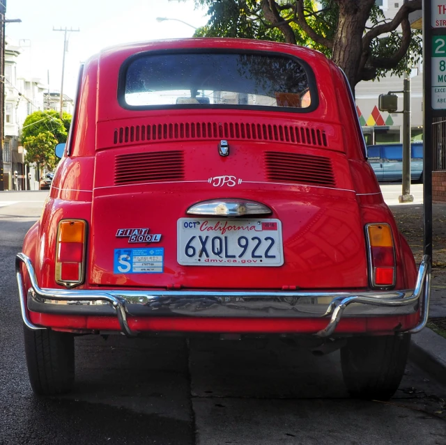 a red classic car with a chrome license plate