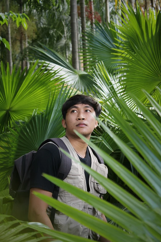 a man wearing a backpack in a jungle setting