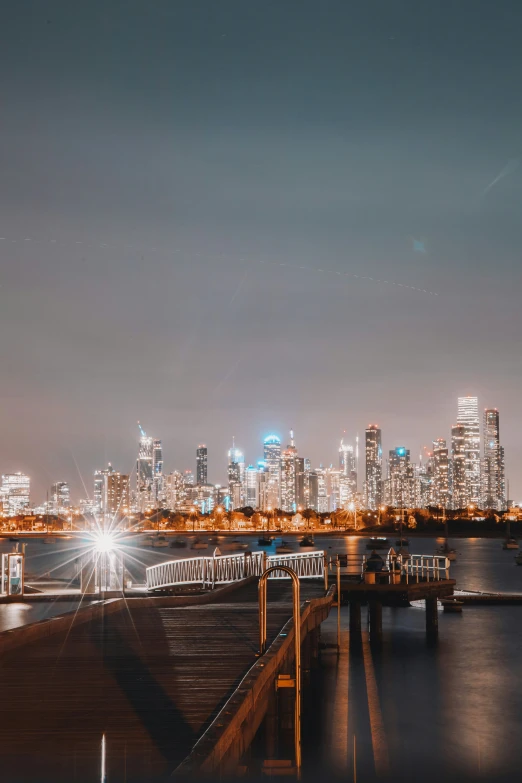 a large cityscape with a long pier and lights