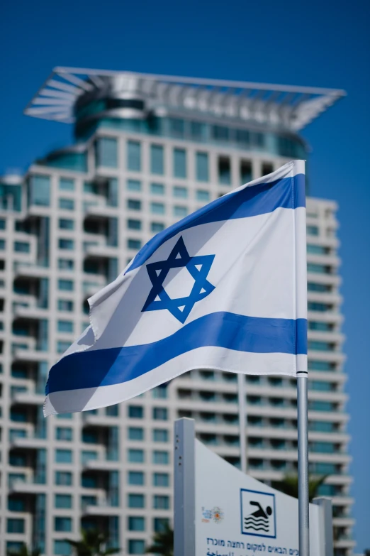 an israeli flag flies by the flag pole