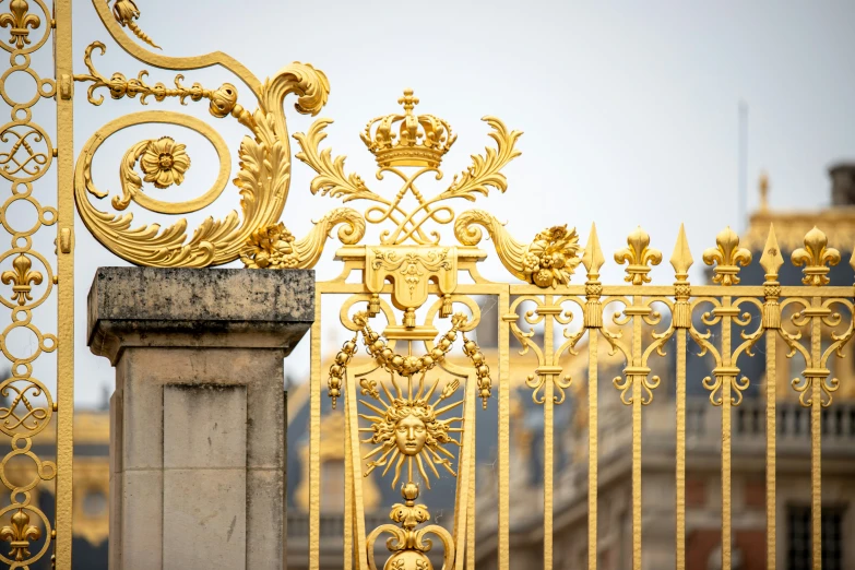 the gold fence has an ornate design and is shown