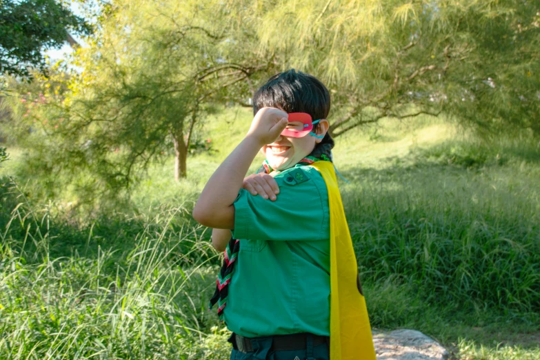 a man wearing green and yellow standing in a field