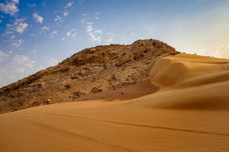 a hill on top of a desert under a blue sky