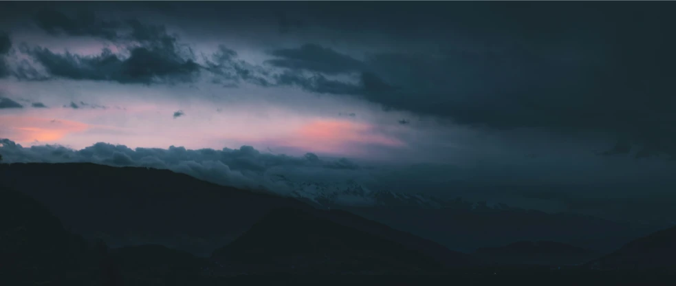 the sky and clouds in front of a mountain